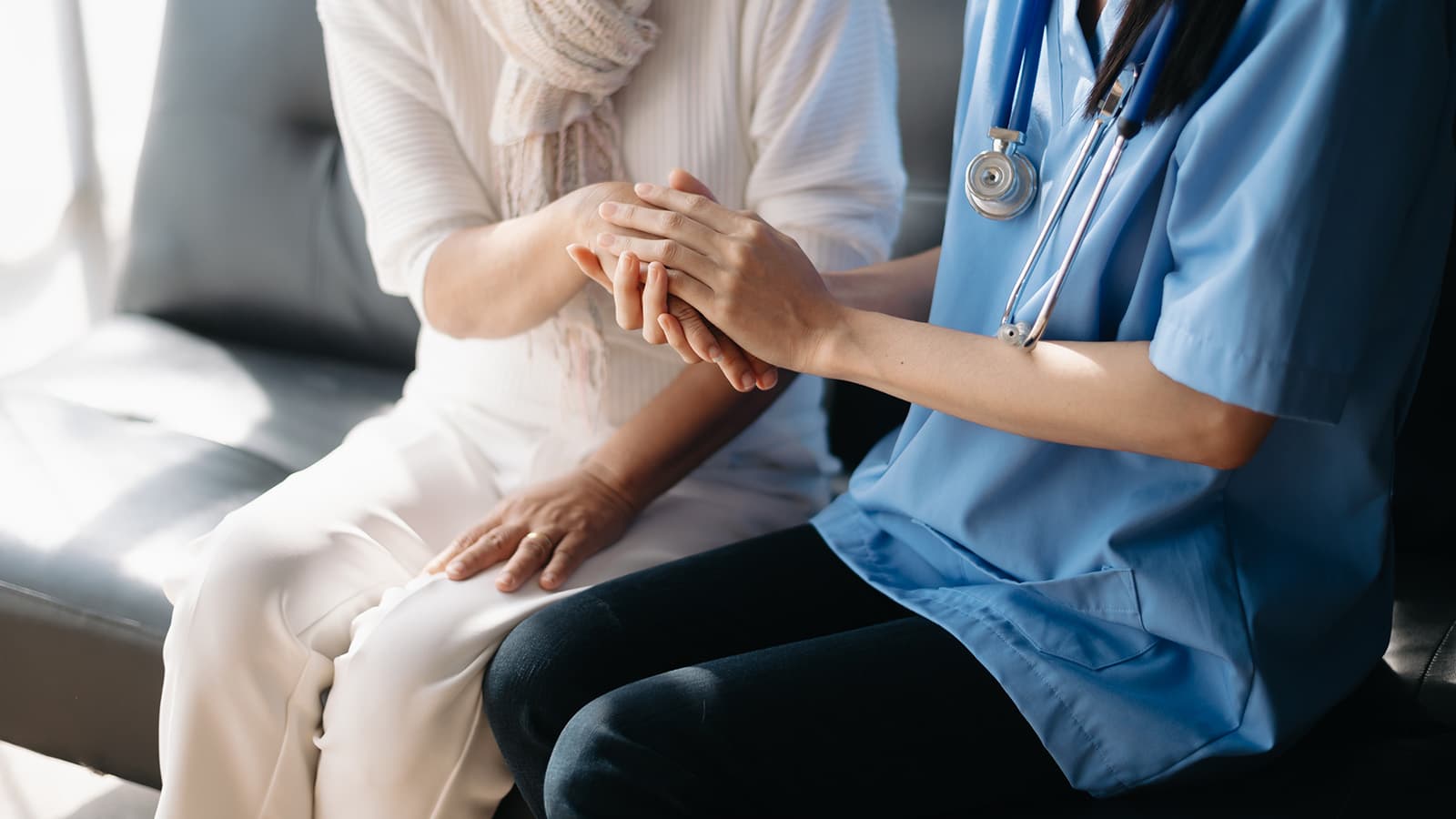 Caregiving holding patient's hands