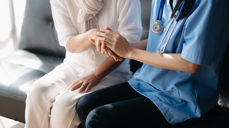 Caregiving holding patient's hands